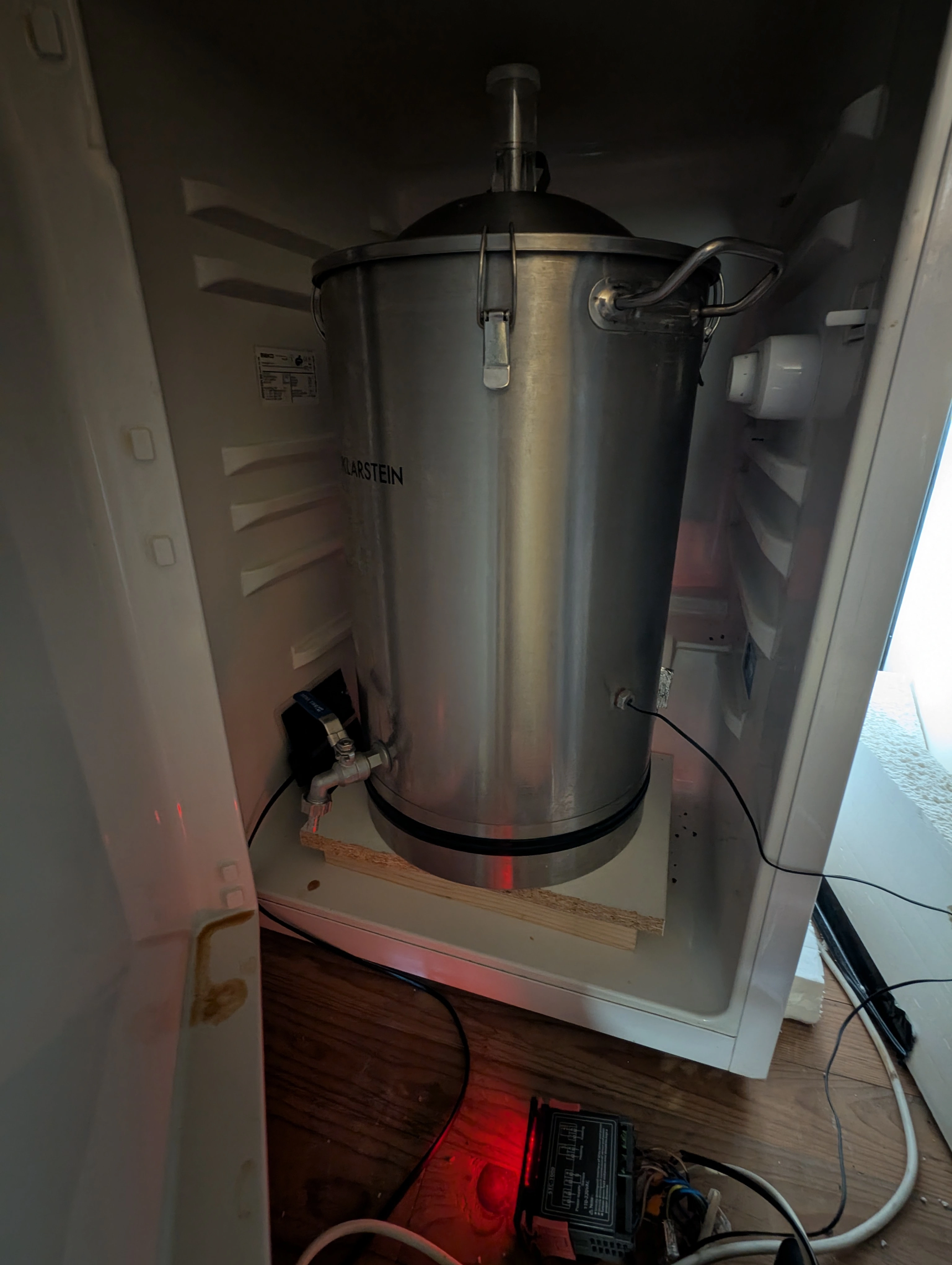 A picture inside the fermentation fridge with the temperature probe well